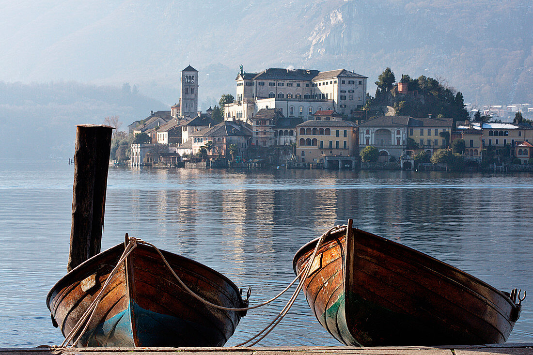 Orta, Orta lake, Novara province, Piedmont, Italy, Europe. Two wooden boats on the shore in front of San Giulio island