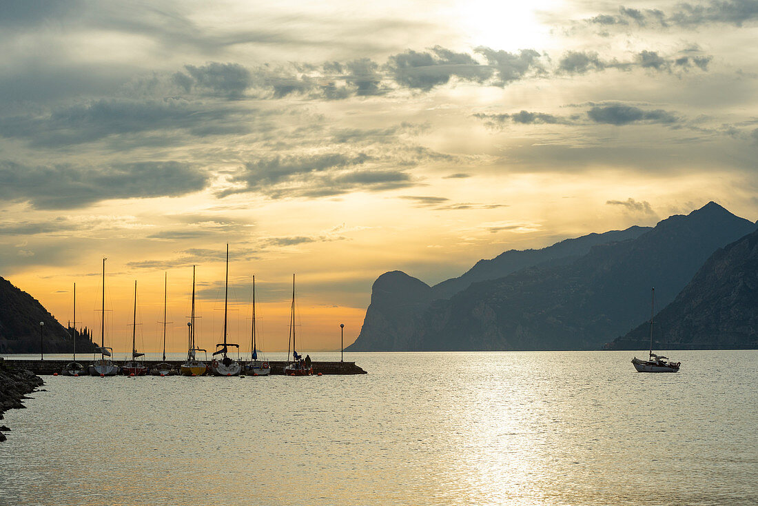 Torbole, Provinz Trient, Südtirol, Italien, Europa, Segelboot fährt zurück zum Pier bei Sonnenuntergang