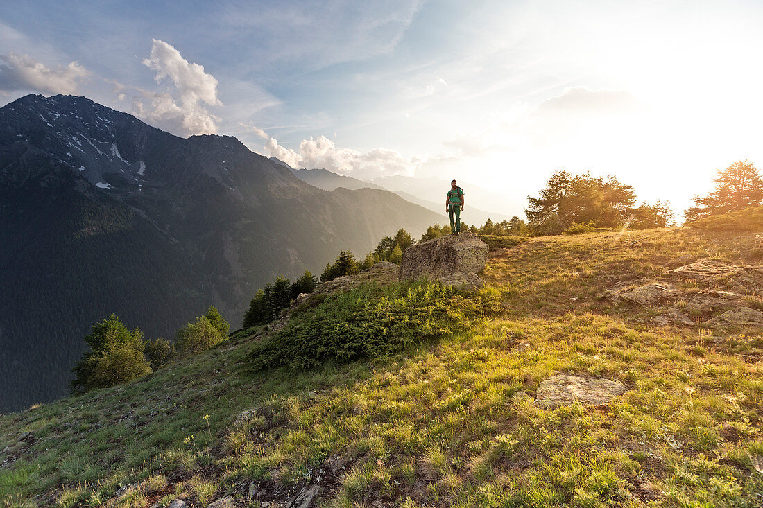 Wanderer auf einem Felsen bei Sonnenuntergang, Ozein, Aymavilles, Aostatal, Italien