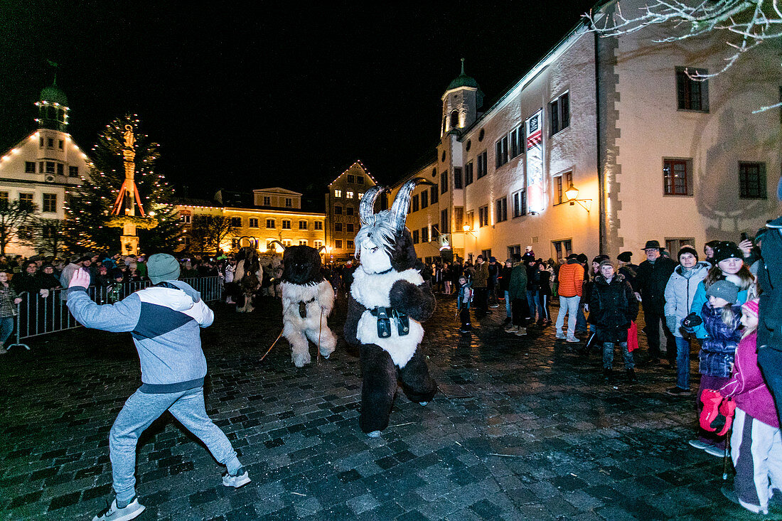 Two krampuses run behind a boy through the old town, Klausenttrieb, Immenstadt im Allgäu, Oberallgäu, Bavaria, Germany, Europe