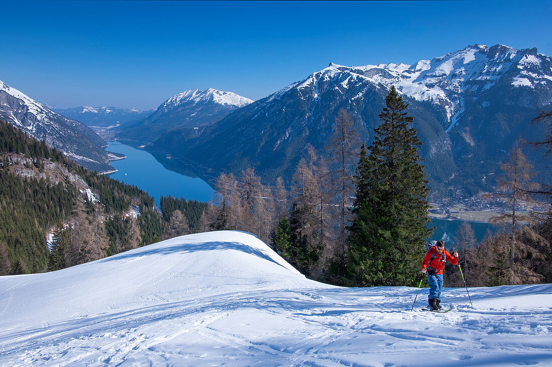 Man on ski tour on Achensee to the summit of Bärenkopf in spring