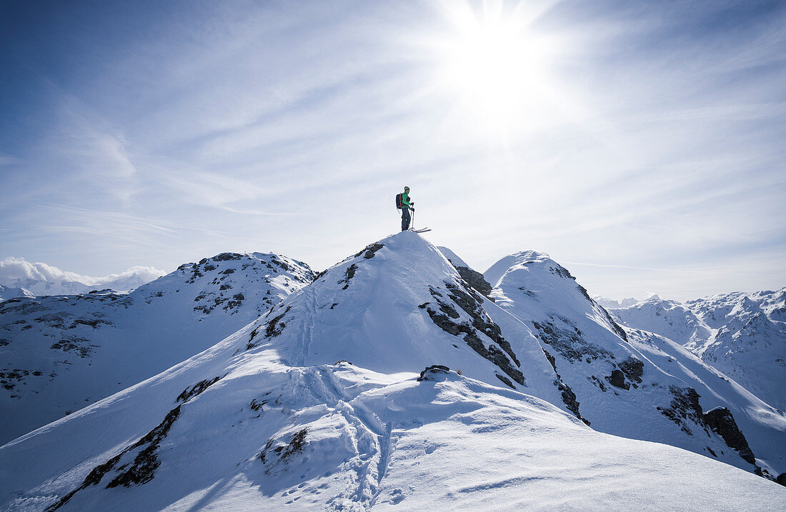 Skifahrer am Gipfelgrat kurz vor der Abfahrt im Tiefschnee in Hochfügen, Winter in Tirol, Österreich