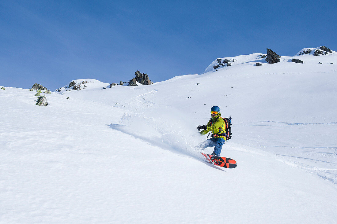 Snowboarder turn with splitboard in deep snow in the Zillertal Alps, Hochfügen