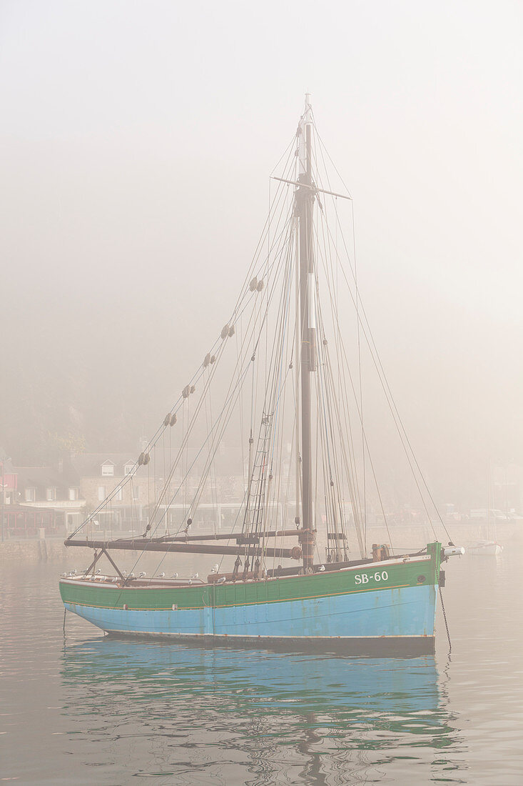 Altes Segelschiff im Hafen von Equy im dichten Morgennebel. Bretagne, Côte d Armor, Frankreich