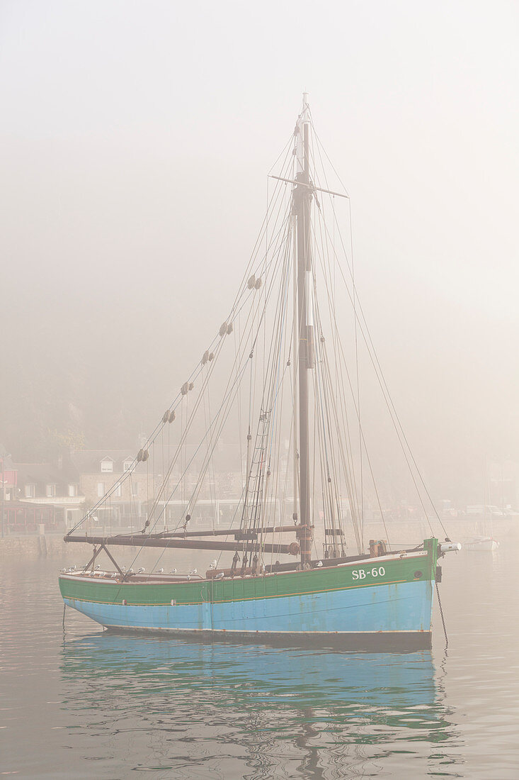 Old sailing ship in the port of Equy in the dense morning fog. Brittany, Cote d Armor, France