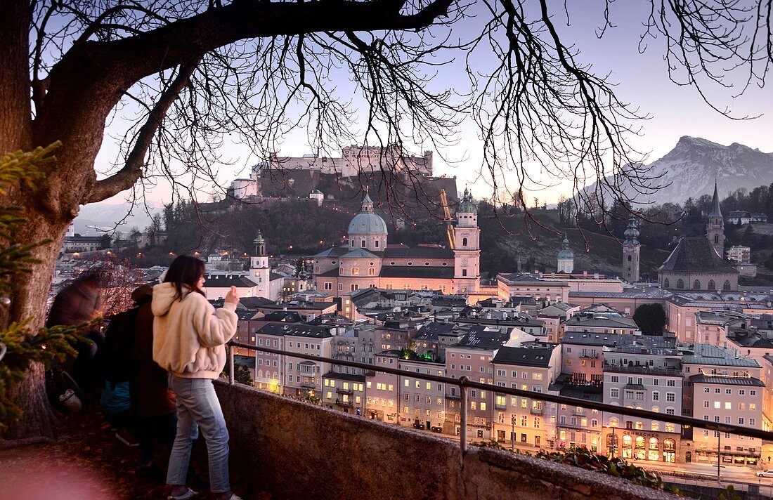 Evening view from Kapuzinerberg, tourists, city view, panorama, branches, lights, river, castle, cathedral, reflections, Stadthäuserm Salzburg in winter, Austria