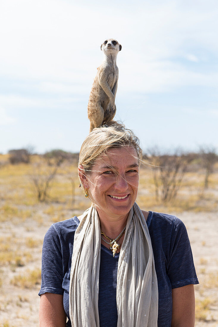 adult woman with Meerkat on her head, Kalahari Desert, Makgadikgadi Salt Pans, Botswana