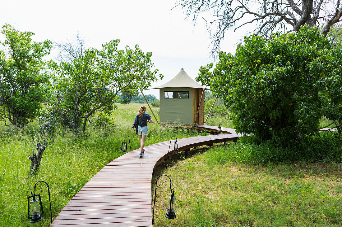 Dreizehnjähriges Mädchen auf Holzsteg, Zeltcamp, Botswana