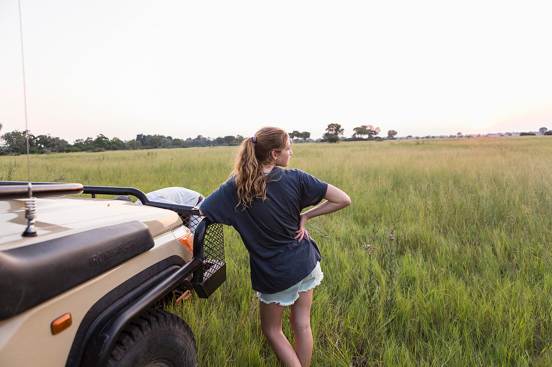 13 year old girl leaning on safari vehicle, Botswana