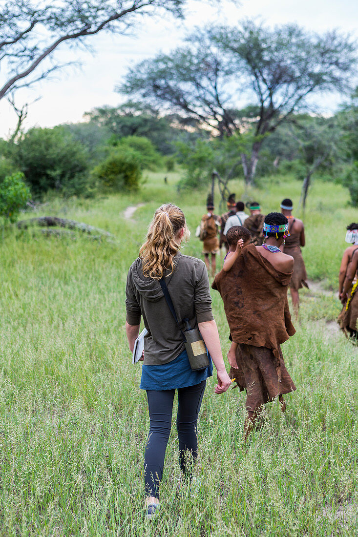 Touristen mit Angehörigen des San-Volkes auf einem Wanderweg