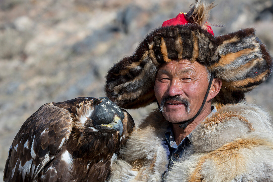 Porträt des kasachischen Adlerjägers Dalaikhan und seines Steinadlers in der Nähe der Stadt Ulgii (Ölgii) in der Provinz Bajan-Ölgii in der Westmongolei