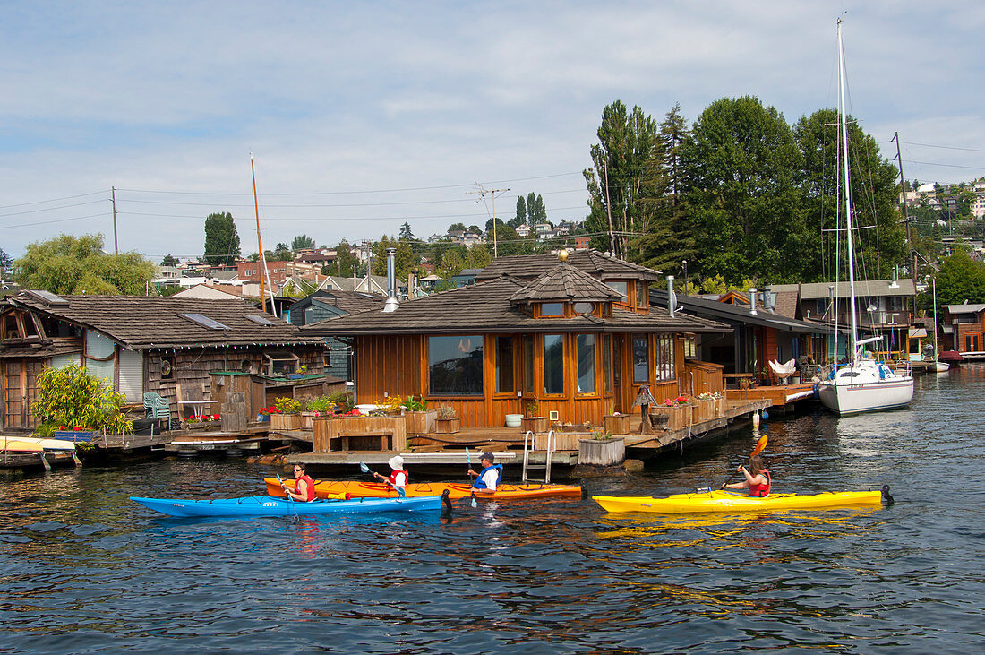 People kayaking along the houseboats on Lake Union in Seattle, Washington State, USA.