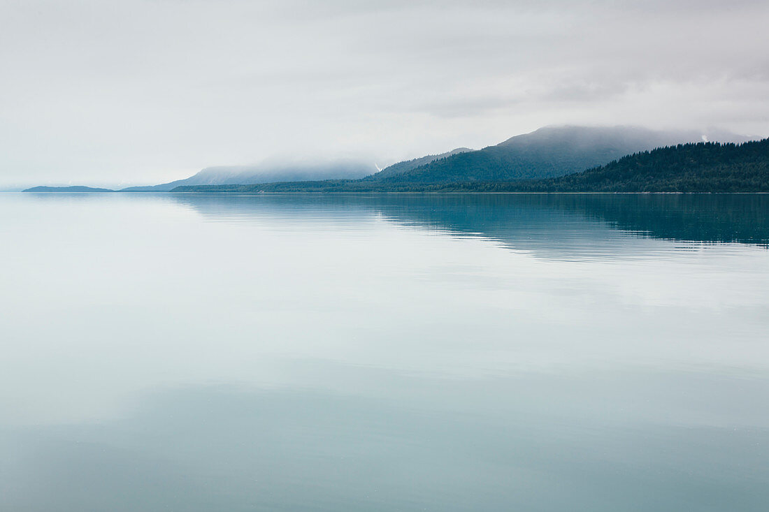 Bedeckter Himmel über ruhigem Wasser in einer Bucht in einem Nationalpark