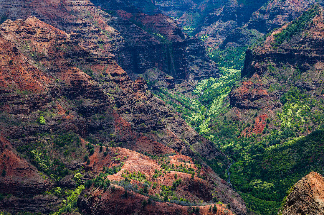 Elevated view of deep canyons, green fertile valleys and steep peaks of an island landscape