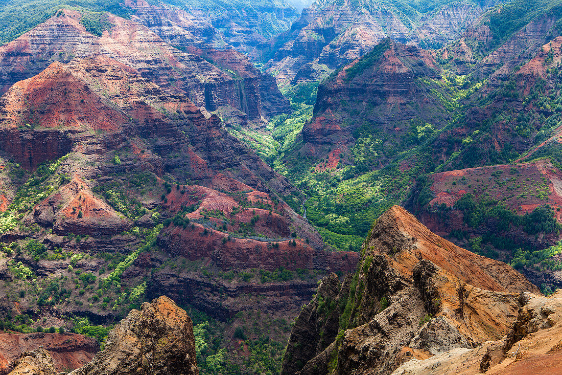 Elevated view of deep canyons, green fertile valleys and steep peaks of an island landscape