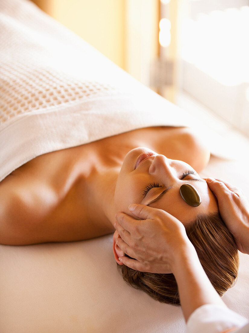 Woman lying on massage table receiving facial stone massage at a luxury spa in Napa Valley California