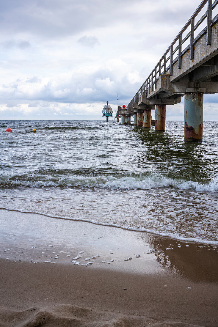 Dramatic scene at the Zinnowitz pier with a rough sea, waves and cloudy sky, Usedom, Mecklenburg-Western Pomerania, Germany