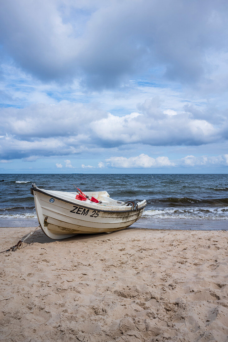 Fishing boat on the Baltic Sea beach with cloudy, dramatic sky and rough sea, Usedom, Mecklenburg-Western Pomerania, Germany