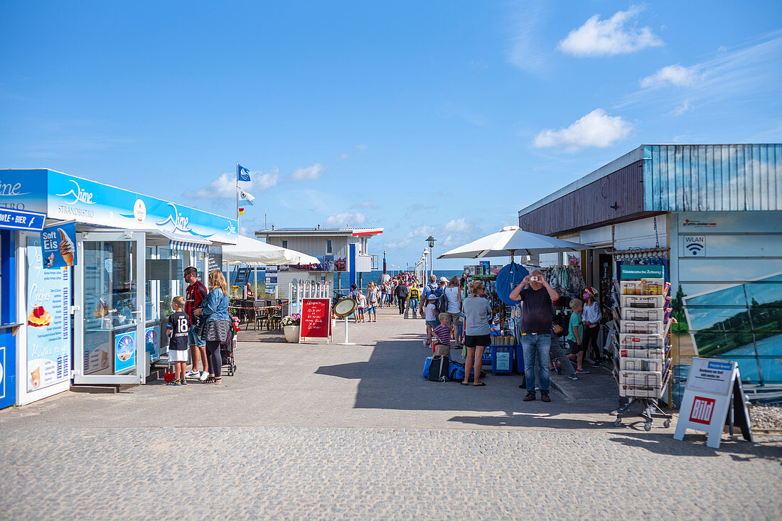 Access to the pier in Zinnowitz with a blue summer sky with people and shops, Usedom, Mecklenburg-Western Pomerania, Germany