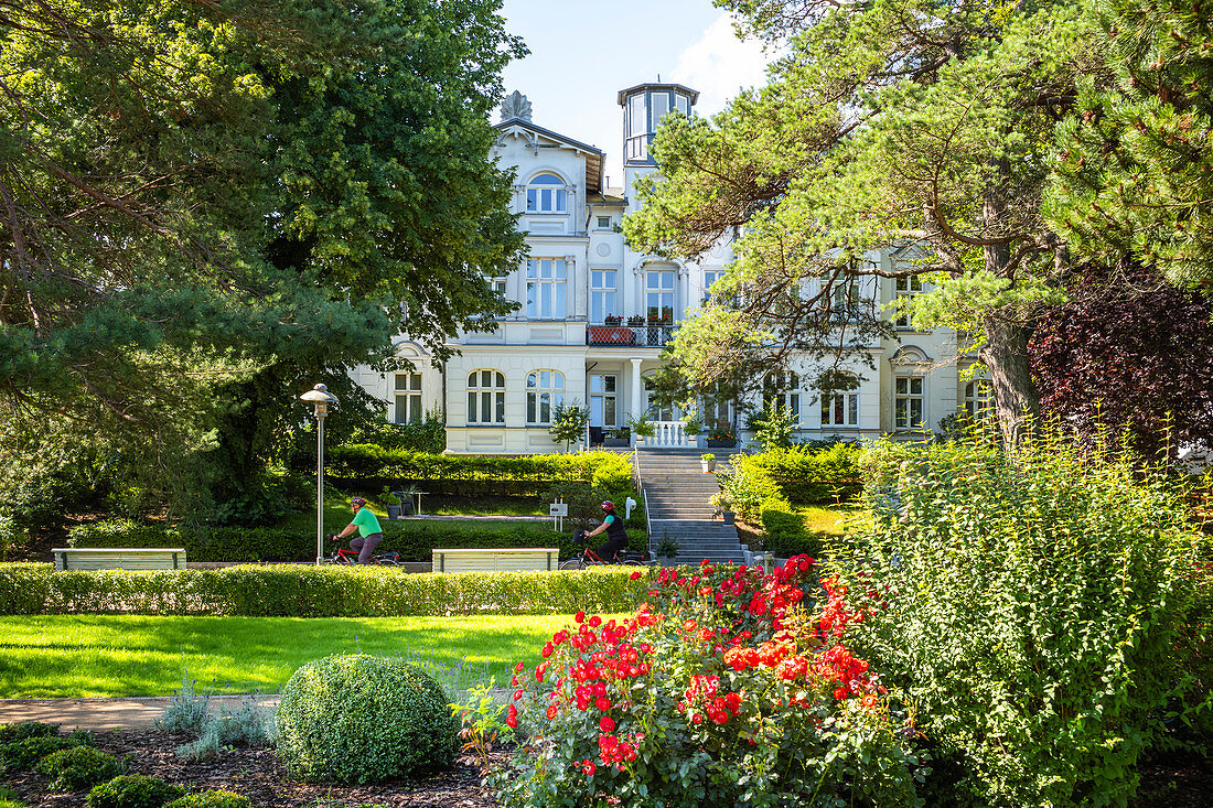 Grünanlage in Zinnowitz mit Rosen vor einer alten Villa und Touristen, Usedom, Mecklenburg-Vorpommern, Deutschland