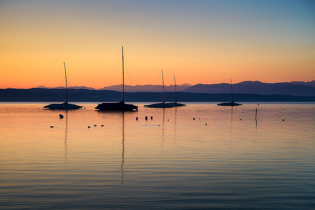 Boote im Gegenlicht, bei Sonnenaufgang auf dem Starnberger See, Tutzing, Bayern, Deutschland