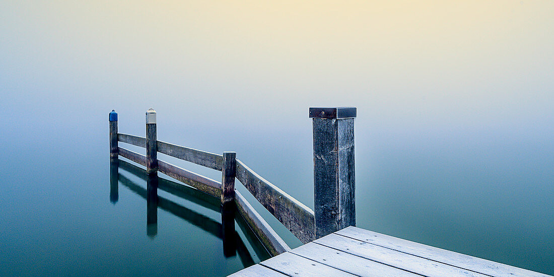 Beschneiter Steg in Marina bei nebligen Sonnenaufgang am Starnberger See, Seeshaupt,  Bayern, Deutschland