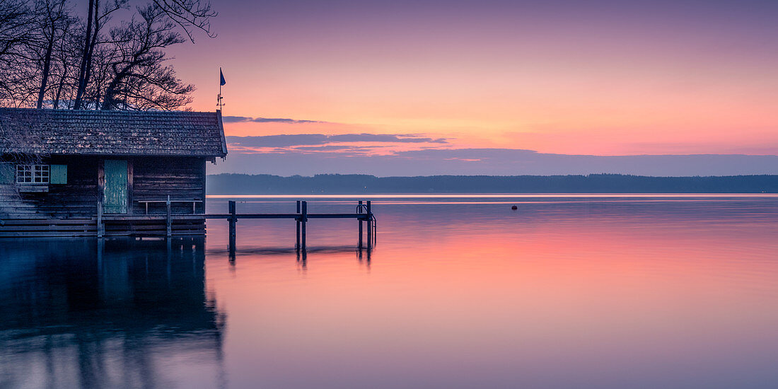 Boat hut and jetty at sunrise on Lake Starnberg, Bavaria, Germany