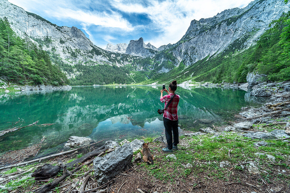 View over the small Gosau lake to the Dachstein and Dachstein glacier with woman in the foreground.