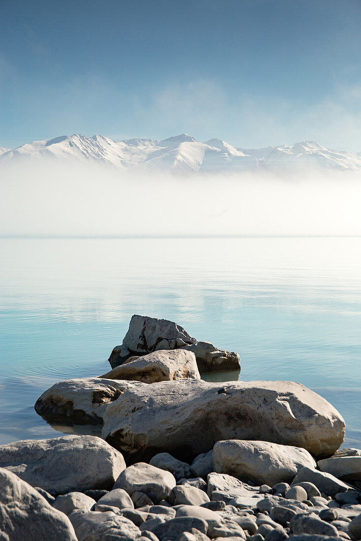 View of snow capped mountains on the horizon from Lake Pukaki in Canterbury, New Zealand.