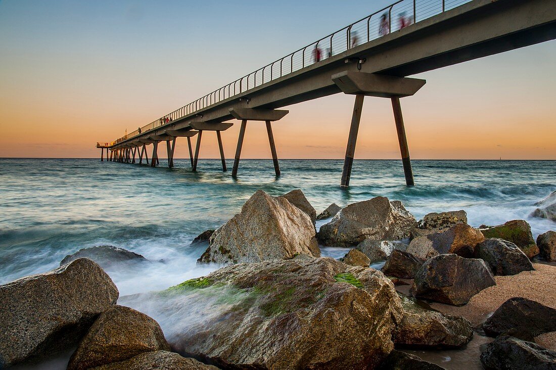 Badalona-Brücke bei Sonnenuntergang mit dem bewegten Meer, Spanien