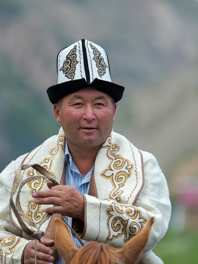 Participant in traditional garb. Folk Festival commemorating the origin myth the Tien Shan Maral (Tian Shan wapiti), an origin myth of the Kyrgyz tribes. Near Tasch Baschat, Naryn region. Asia, Central Aisa, Kyrgyzstan