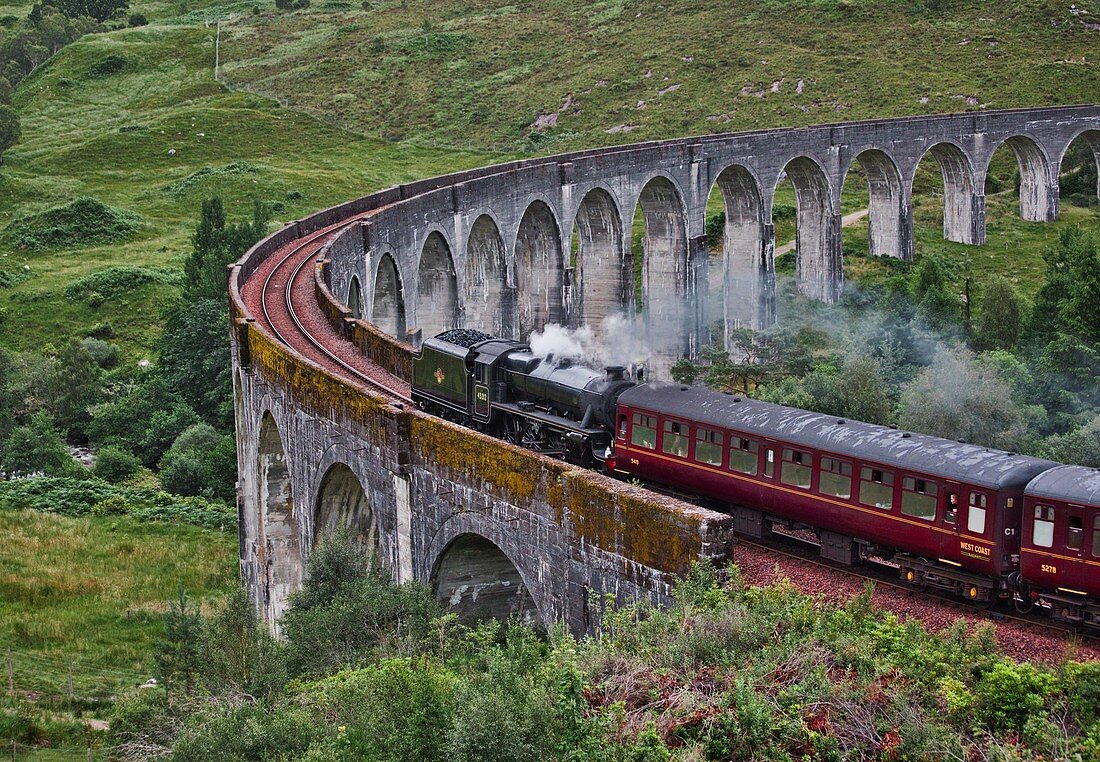 Jacobite Steam Train (dampfbetriebener Museumszug) über das Glenfinnan-Viadukt auf der Strecke von Mallaig nach Fort William, Lochaber, West Highlands, Schottland