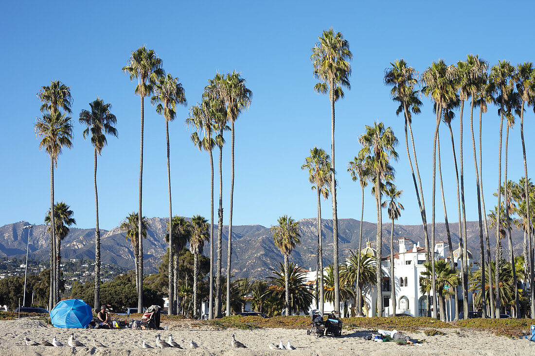 Homeless people on the beach against the backdrop of the Santa Ynez Mountains in Santa Barbara, California, USA.