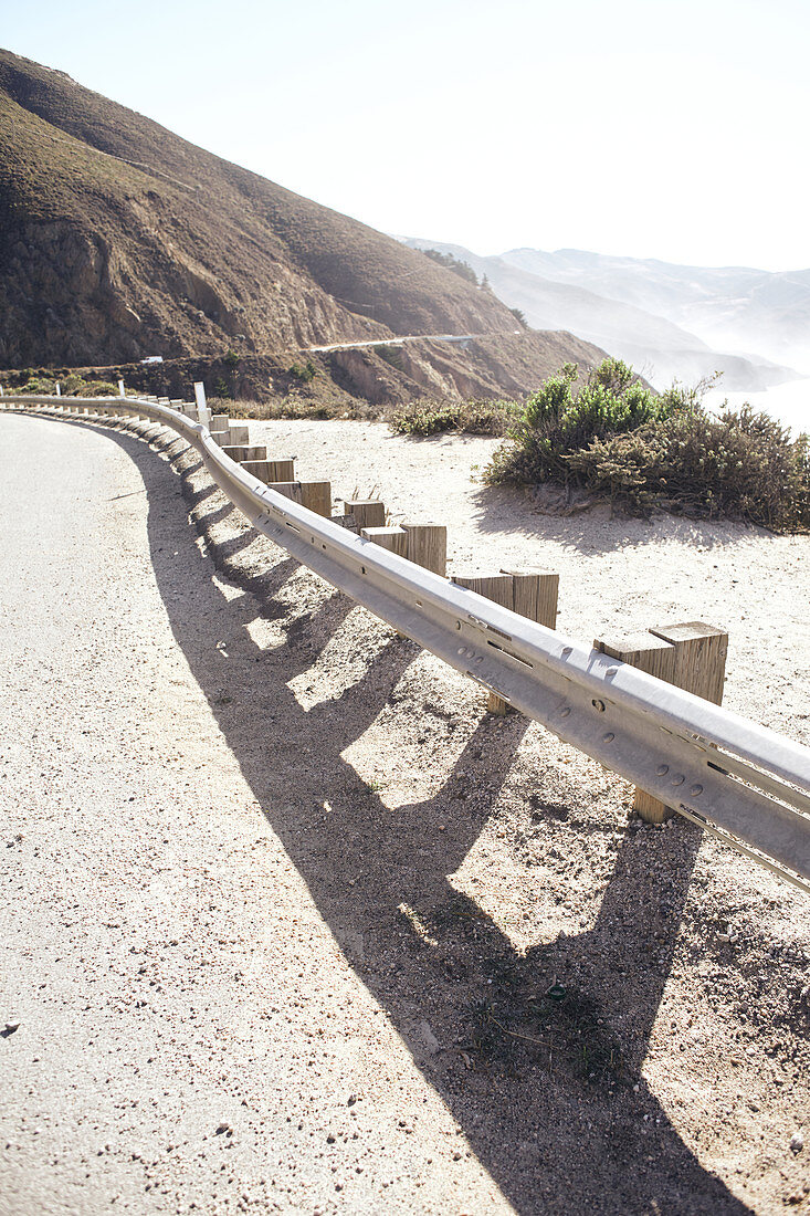 Guardrail on Highway 1 with a view of the Santa Lucia Range and the Pacific Ocean, Big Sur State Park, California, USA.