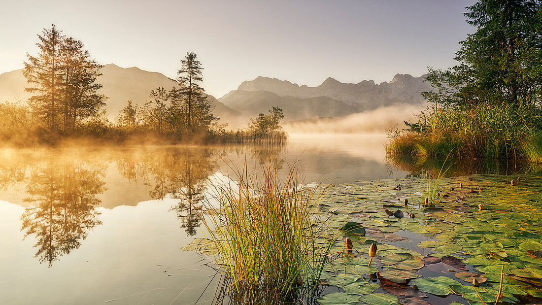 Sunrise at the Barmsee with a view towards the Karwendel massif, Bavaria, Germany.
