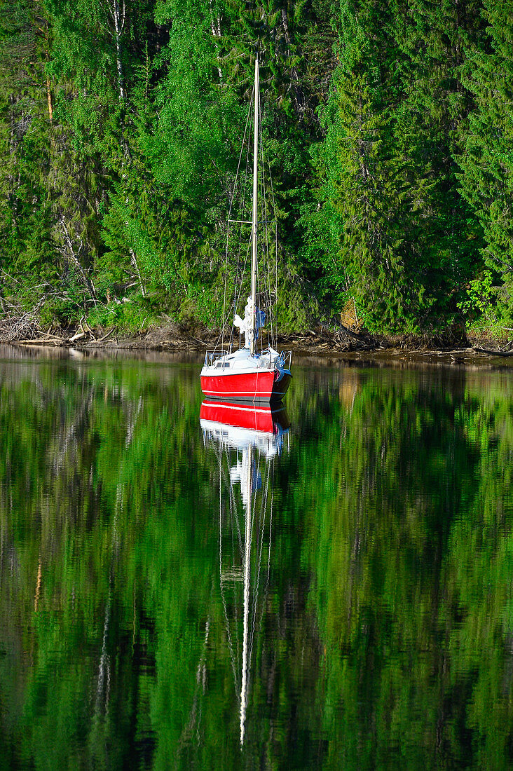 Ein Segelboot im See spiegelt sich im Wasser, Junsele, Norrbottens Län, Schweden
