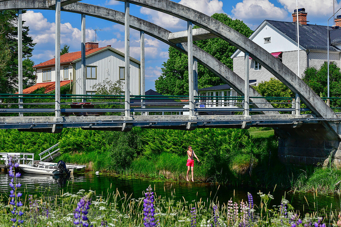 Ein Junge springt von einer Brücke in den Fluss, Leksand, Provinz Dalarna, Schweden