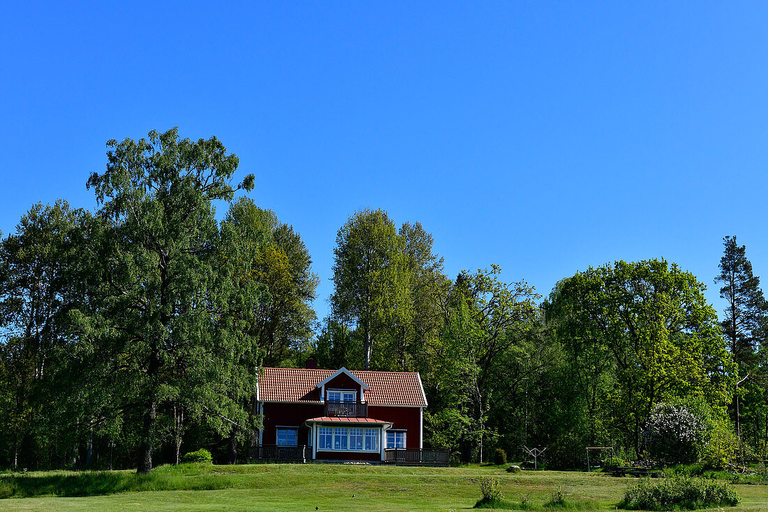 Ein typisches rotes Schwedenhaus mit großem Garten bei Tranhult, Schweden