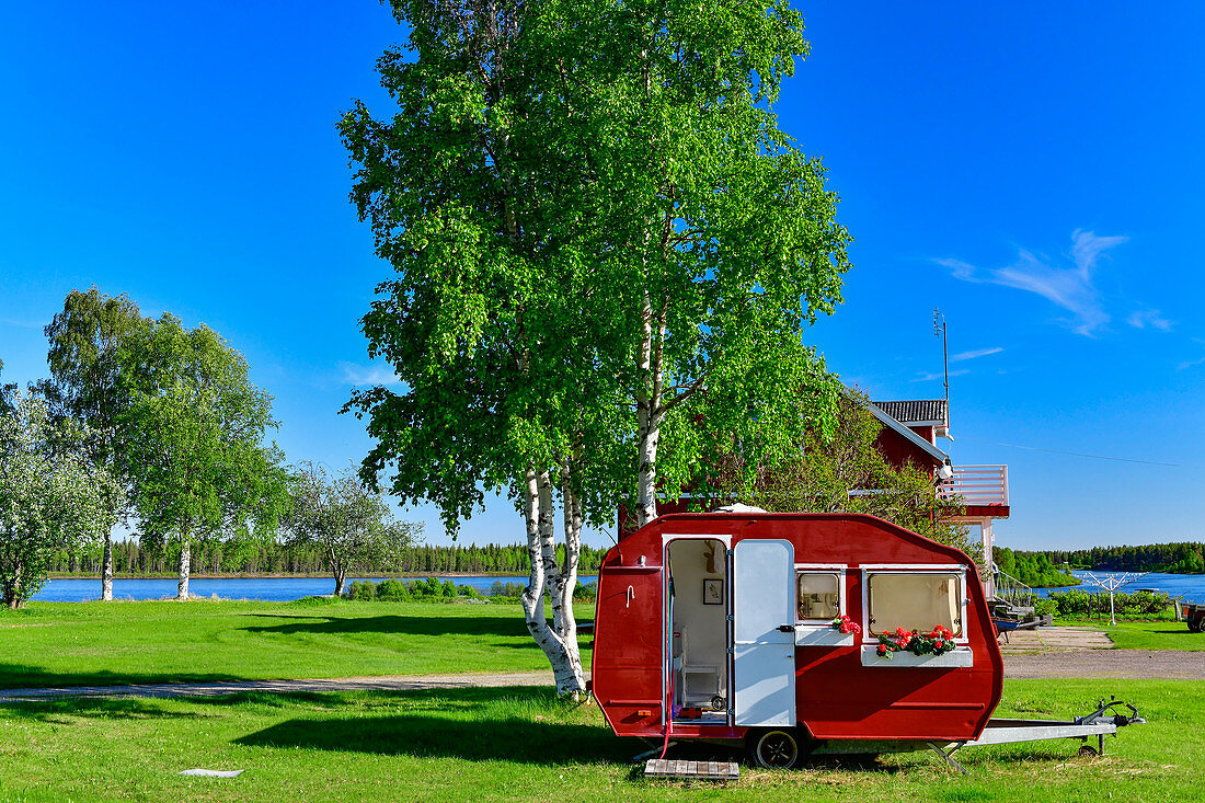 Dekorierter roter Wohnwagen in einem Vorgarten, Lovikka, Norrbottens Län, Schweden