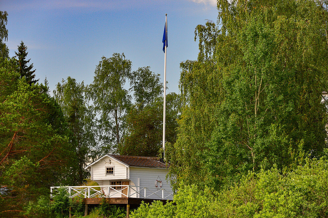 Kleines Sommerhaus mit Veranda und Schwedenfahne im Wald, Näs bruk, Avesta, Dalarna, Schweden