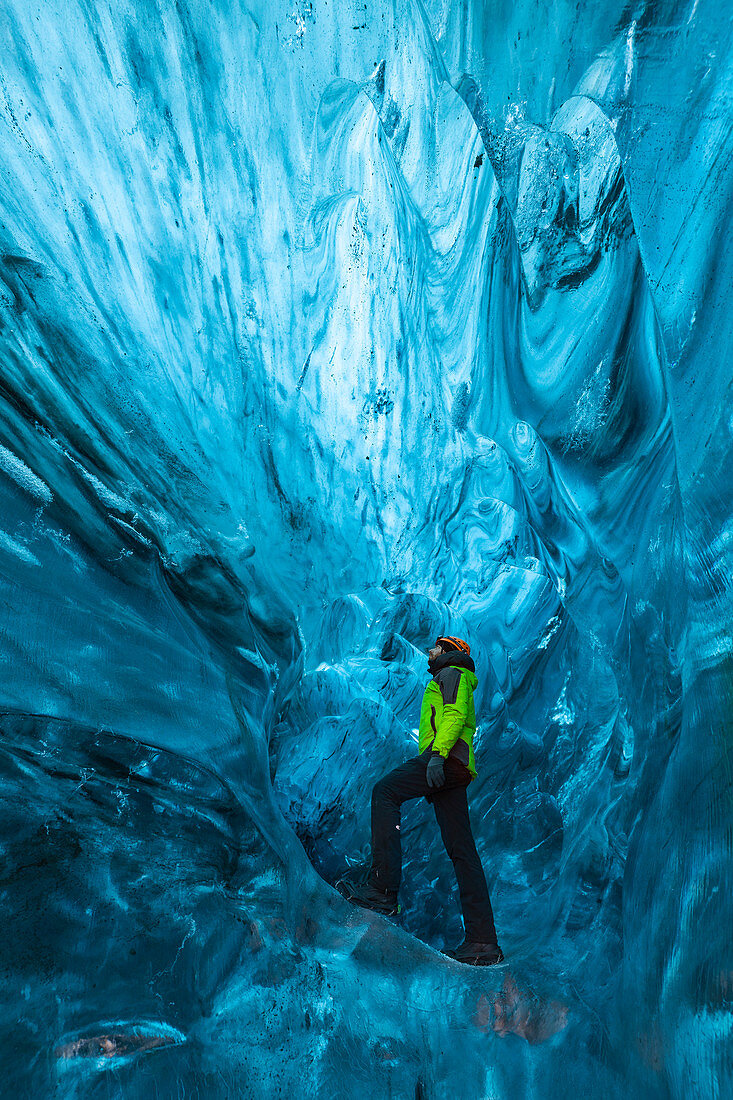 Man stands an ice cave of Breidamerkurjokull, Austurland, Iceland, Northern Europe
