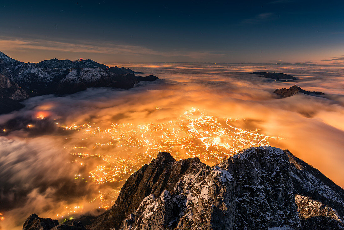 The city of Lecco appears under the fog during sunset, Coltignone Mount, Piani Resinelli, Lecco province, Lombardy, Italy, Europe