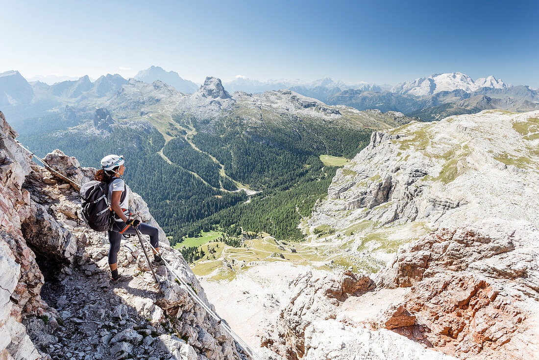 Eine Kletterin entlang des Klettersteigs Lipella auf der Tofana di Rozes betrachtet die Landschaft um sie herum, Provinz Belluno, Venetien, Italien