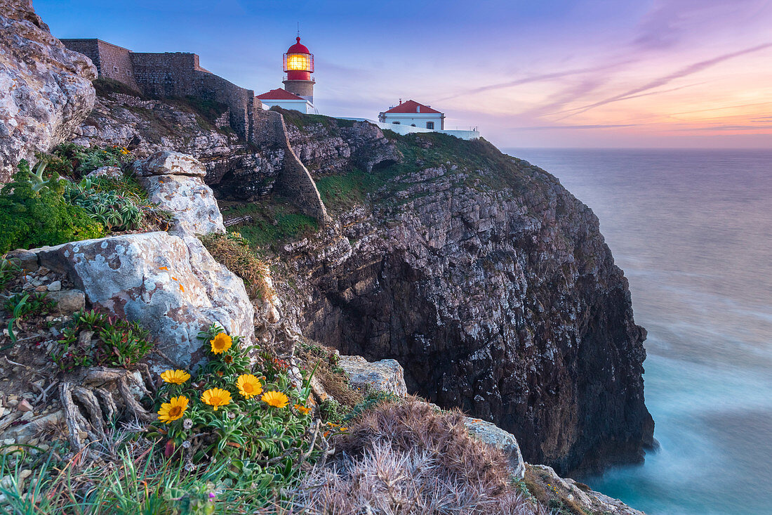 Die Klippen und der Leuchtturm von Cabo De San Vicente bei Sonnenuntergang mit Blick auf den Atlantik, Sagres, Vila do Bispo, Algarve, Portugal, Europa