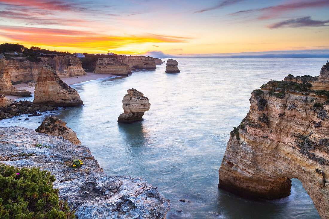 Blick auf die berühmten Naturbögen in Praia da Marinha bei Sonnenaufgang, Caramujeira, Lagoa, Algarve, Portugal, Europa