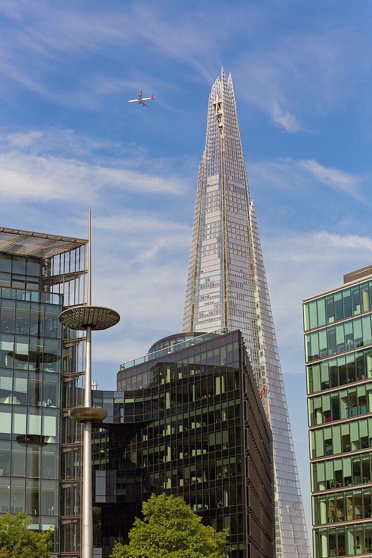 United Kingdom, London, Southwark district, the banks of the River Thames near Tower Bridge, the skyscraper The Shard by architect Renzo Piano, office buildings, airplane in the sky