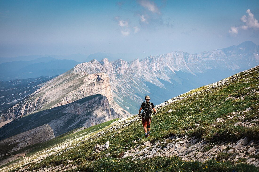 HIKER AT THE SUMMIT OF THE GRAND VEYMONT, VIEW OF THE CRESTS OF THE VERCOR IN THE DISTANCE, GRESSE-EN-VERCORS, ISERE (38), AUVERGNE-RHONE-ALPES, FRANCE