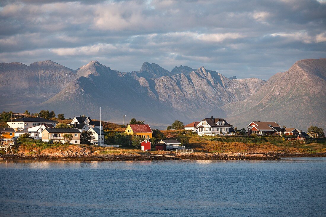 Küstenstadt in einer Gebirgigen Landschaft bei Sonnenuntergang, Sommaroy, Insel Kvaloya, Tromso, Norwegen