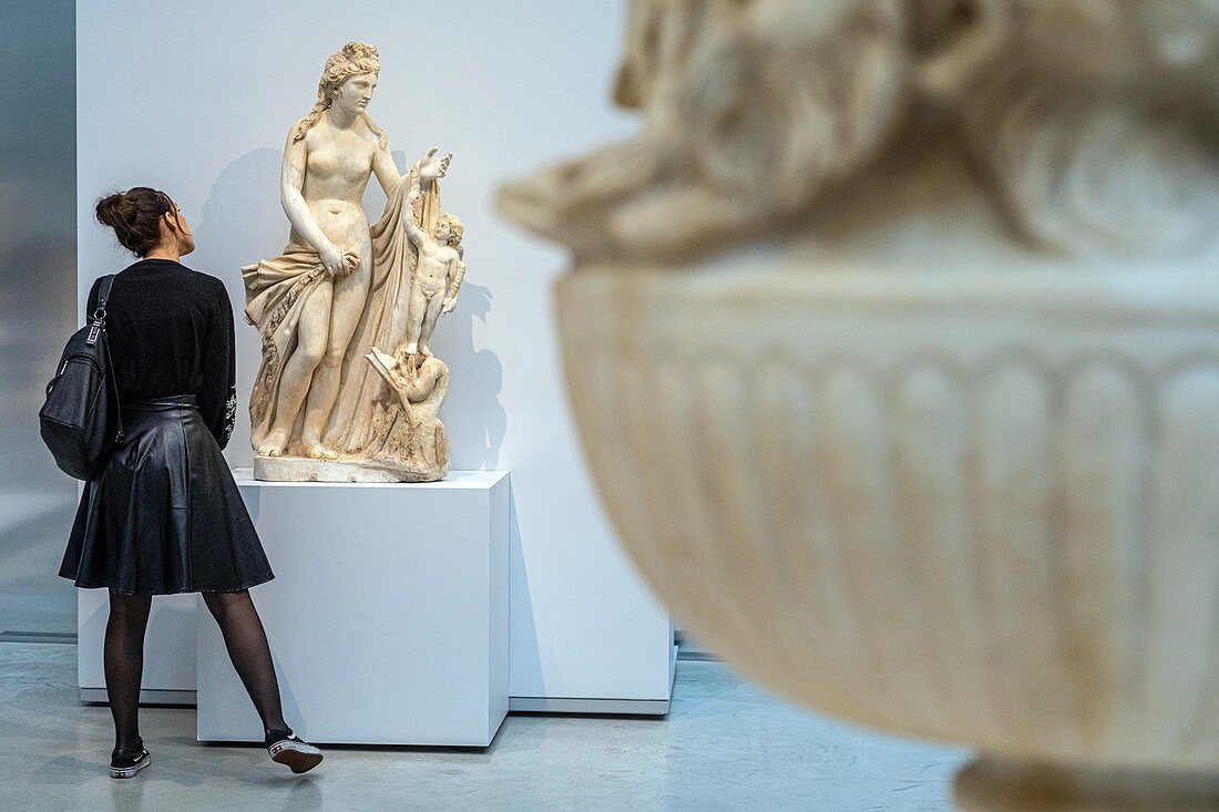 VISITOR IN FRON OF THE SCULPTURE OF VENUS AND LOVE STANDING ON A SEA MONSTER (CIRCA 200-300 AD), GALLERY OF TIME, LOUVRE-LENS MUSEUM, LENS, PAS-DE-CALAIS, FRANCE
