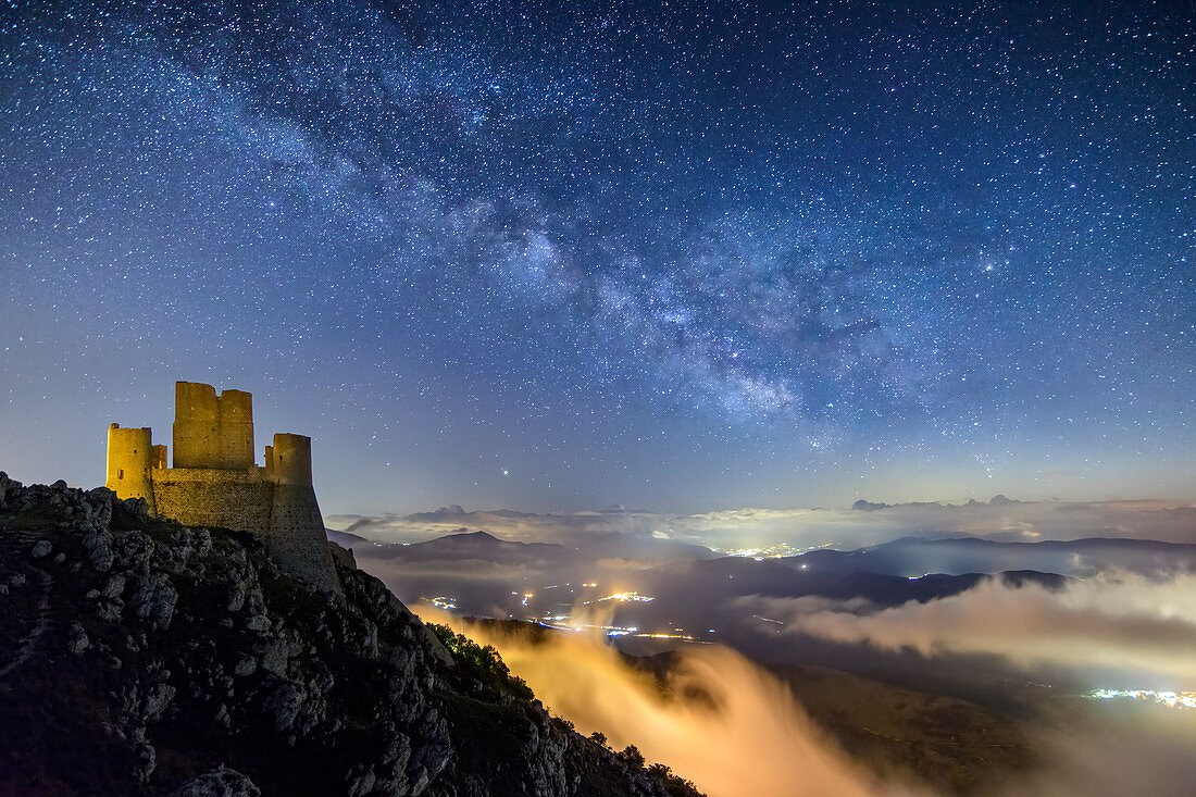 Sternenhimmel mit Milchstraße über beleuchteter Burg Rocca Calascio, Rocca Calascio, Nationalpark Gran Sasso, Parco nazionale Gran Sasso, Apennin, Abruzzen, Italien